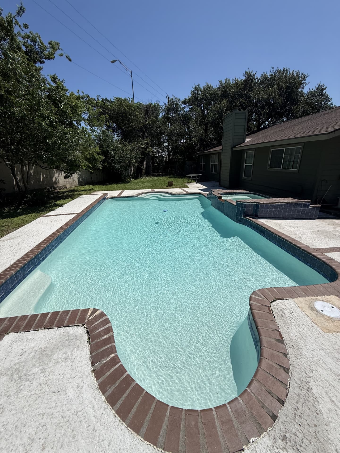 The same backyard pool with clear blue water after Texas Tide Pool Service